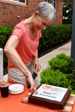 Centre Manager Camilla Davis cuts CUC Mudgee Region's second anniversary cake.